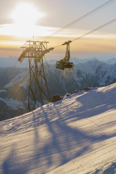 LAAX gondola at sunrise with snow and mountain background